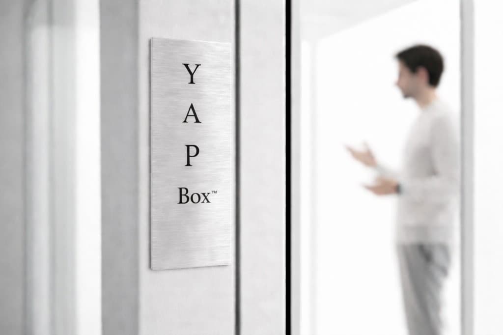 YAP Box plaque mounted beside a glass booth